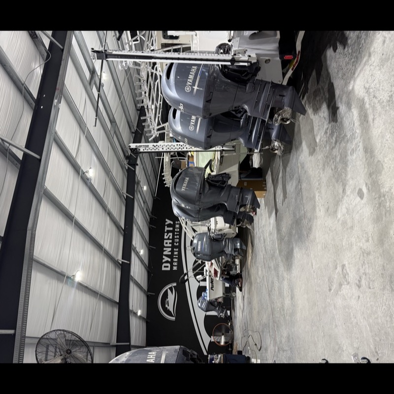Outboard-powered boats lined up inside the Dynasty Marine Customs shop