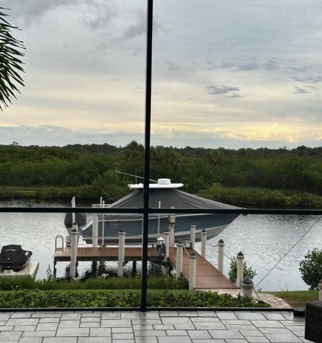 Center console under a custom canvas cover on a boat lift in Sarasota