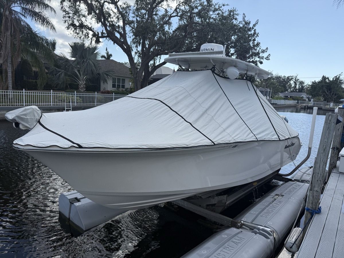 Custom full boat cover fitted over a center console on a lift