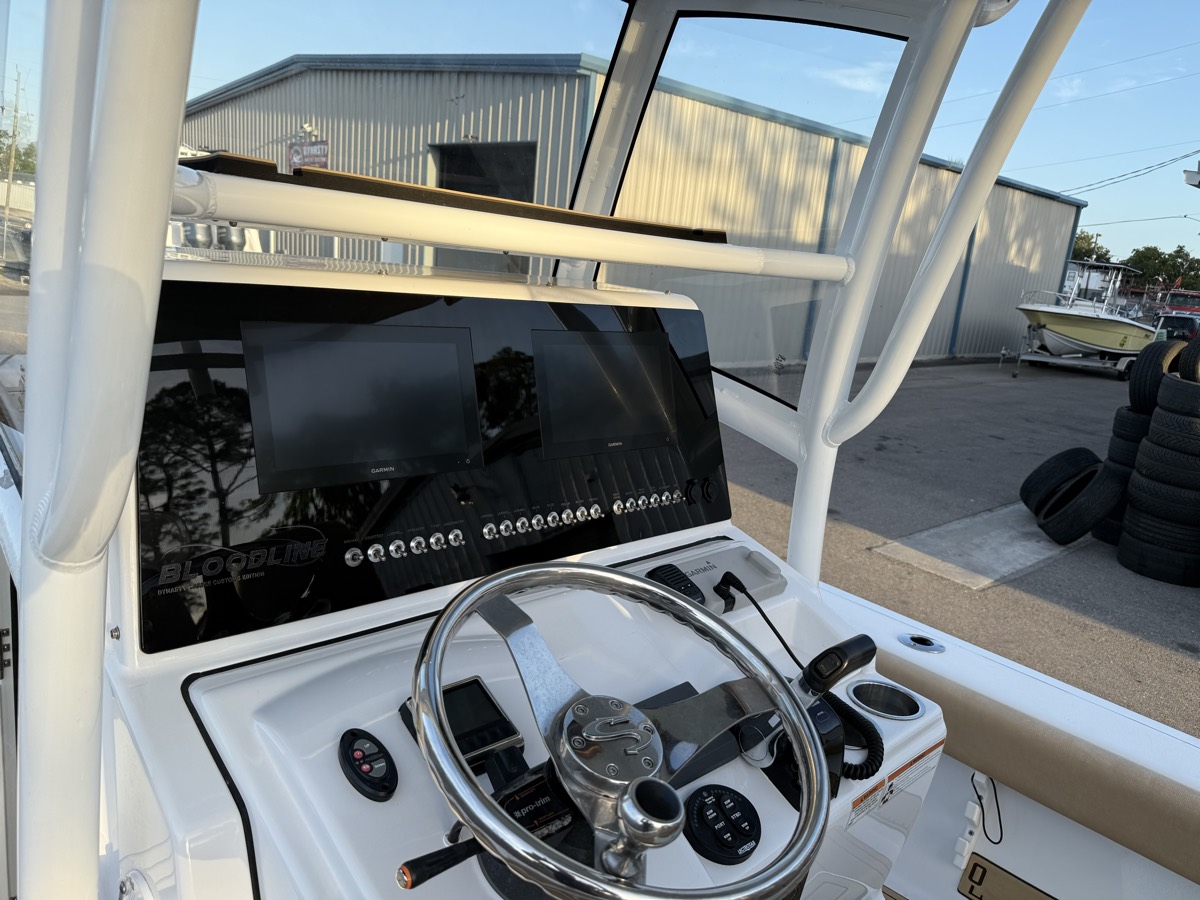 Custom helm dash with switch bank and flush-mounted electronics outside the Dynasty Marine Customs shop